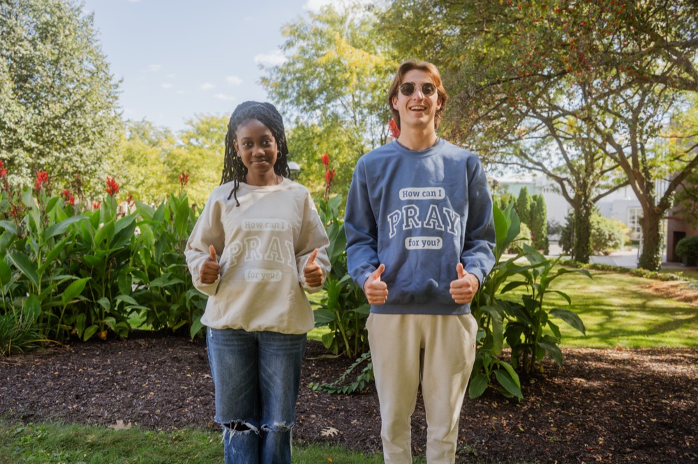 Students wearing "How Can I Pray For You?" sweatshirts